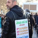 A protestor wears a placard that says: "Jesus was born by Miraculous Assisted Reproduction. One Virgin and two Dads. LOL"Photo: The Local