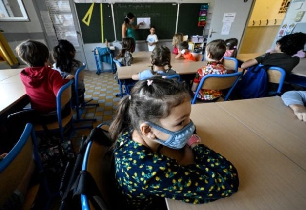 Primary-age school children in a class wearing facemasks to protect against the spread of the Covid-19 virus