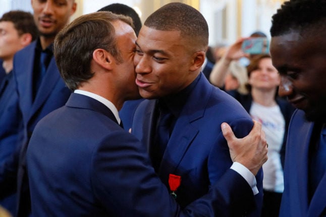 Congratulations kiss: French president Emmanuel Macron embraces Kylian Mbappe during a ceremony to honour France's 2018 World Cup winners.