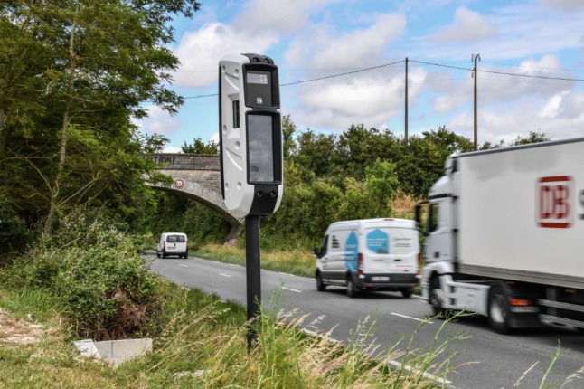 Vehicles drive past a fixed roadside safety camera near La Rochelle, France