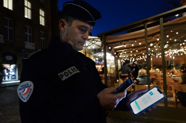 A policeman checks the Covid-19 health pass  in France. The government plans to transform the health pass into a vaccine pass by the end of January.