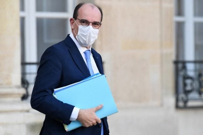 French Prime Minister Jean Castex, wearing a facemask, leaving a cabinet meeting at the Elysee Palace, with a bundle of folders under one arm