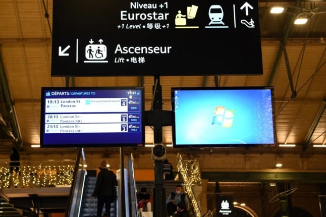 A picture taken on December 16, 2021 shows information boards and screens showing the upcoming Eurostar trains to London at the Gare du Nord railway station in Paris