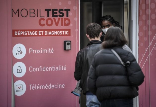 People wait to be tested for Covid at a mobile unit in Paris